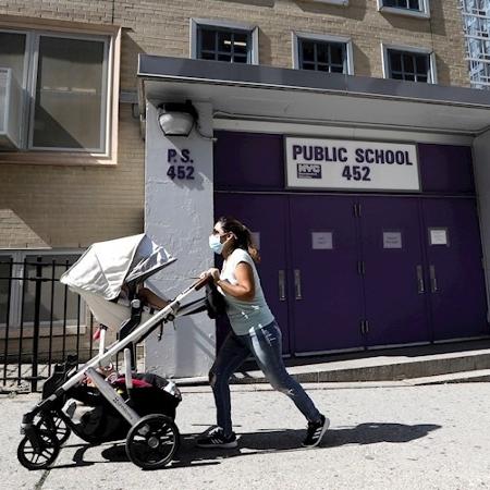 Mulher passa em frente a escola pública fechada em Nova York - EFE/EPA/Peter Foley