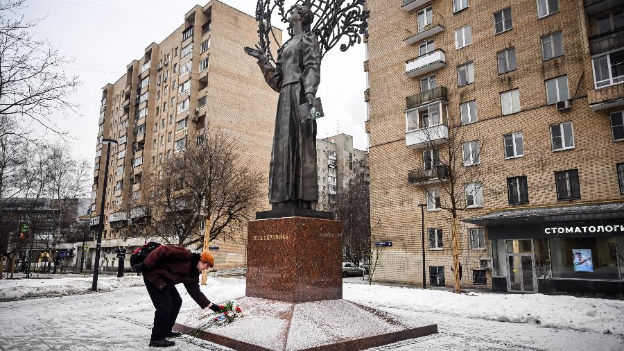 Homem deposita flores no monumento à famosa poetisa ucraniana Lesya Ukrainka, em Moscou, em homenagem  a mortos durante a Guerra na Ucrânia - 23.jan.2023 - Alexander Nemenov/AFP