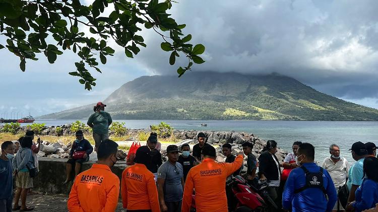 18.abr.2024 - Equipe da agência nacional de busca e resgate da Indonésia observa o vulcão Monte Ruang; vulcão teve cinco erupções, o que forçou as autoridades a fecharem aeroporto próximo da região e a emitirem um alerta de tsunami