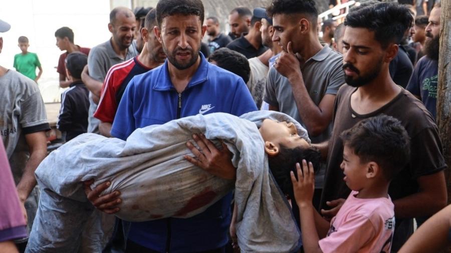 13.jul.2025 - Um palestino carrega o corpo de seu sobrinho Saraj Ibrahim, morto em um ataque israelense que atingiu Nuseirat, no centro da Faixa de Gaza
