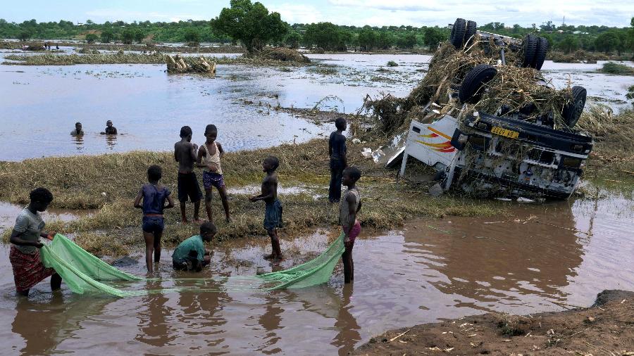 Crianças usam um mosquiteiro para capturar peixes perto de um naufrágio, arrastados durante a tempestade tropical Ana no rio inundado, no distrito de Chikwawa, sul do Malawi - REUTERS/Eldson Chagara