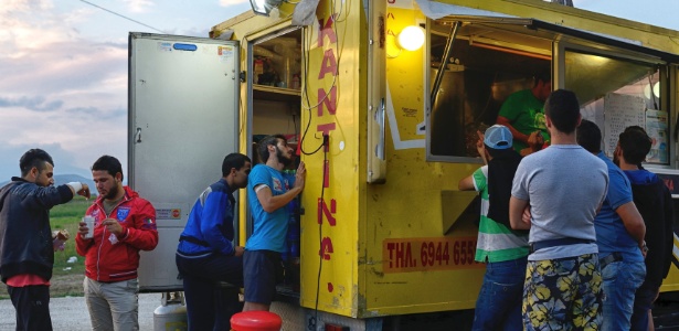 Refugiados em barraca de comida na Grécia; imigrantes movimentaram comércio local - Samuel Aranda/The New York Times