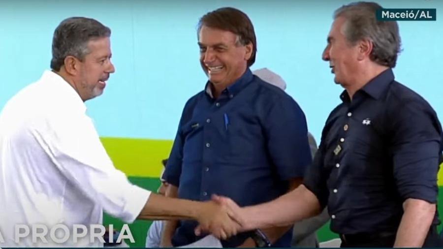 Lira aperta a mão de Collor após discursar enquanto Bolsonaro sorri, em Maceió - Reprodução