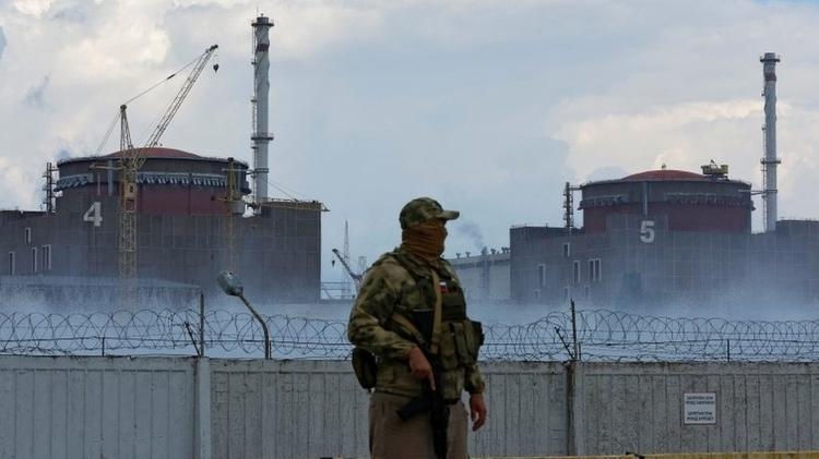 A soldier with reactors four and five in the background - Reuters - Reuters
