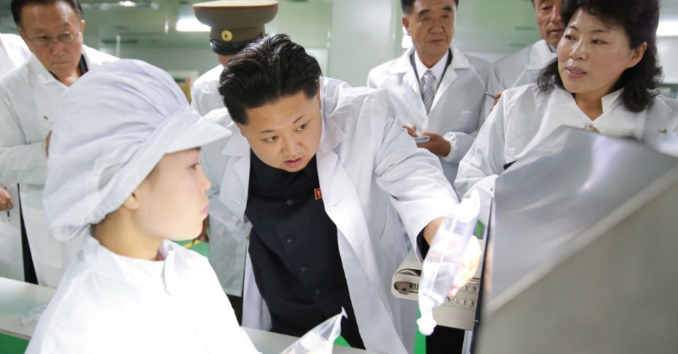 2.out.2015 - O líder da Coreia do Norte, Kim Jong-un, presta atenção em detalhes de máquina durante visita a uma fábrica farmacêutica, em foto sem data ou local específico divulgada pela agência oficial KCNA