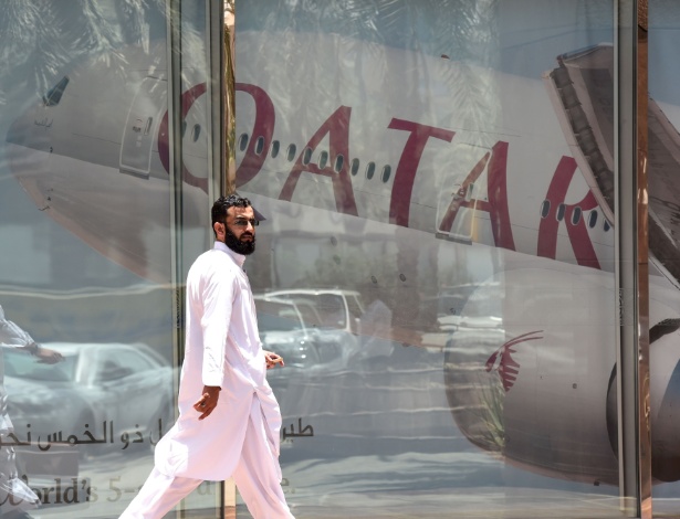 Homem passa diante de anúncio da Qatar Airways em Riad, na Arábia Saudita - Fayez Nureldine/ AFP