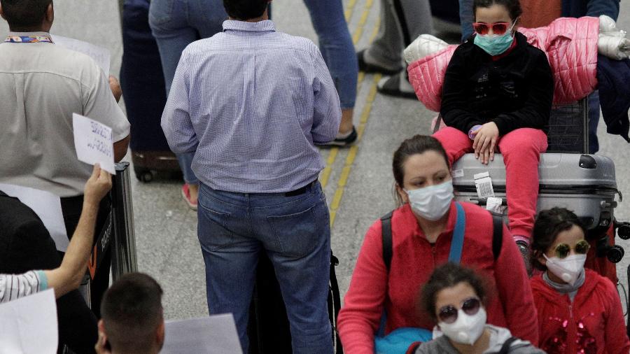 Passageiros com máscara de proteção no aeroporto do Galeão, no Rio de Janeiro - RICARDO MORAES