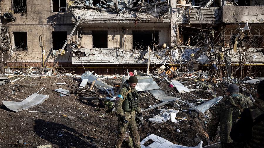Soldado ucraniano inspeciona os escombros de um prédio de apartamentos destruído em Kiev - FADEL SENNA/AFP