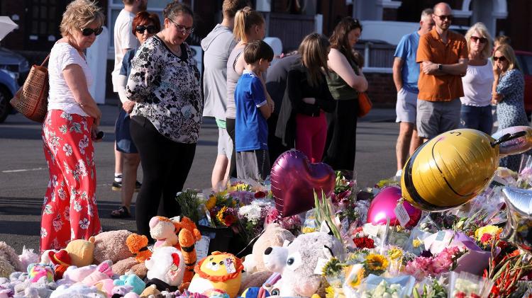 Público observa homenagem com flores, balões e bichos de pelúcia, para as crianças assassinadas e feriadas em ataque em Londres 