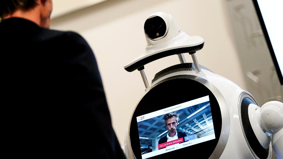 Funcionário da empresa ZoraBots testa robô no hospital da Universidade da Antuérpia. Ele verifica a temperatura dos visitantes e se eles estão usando máscaras - Kenzo Tribouillard - 29.mai.2020/AFP