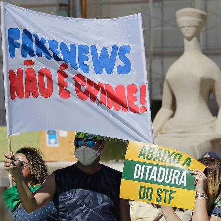 31.mai.2020 - Apoiador do presidente Jair Bolsonaro exibe faixa em que diz que notícia falsa não seria crime em manifestação em Brasília - Dida Sampaio/Estadão Conteúdo