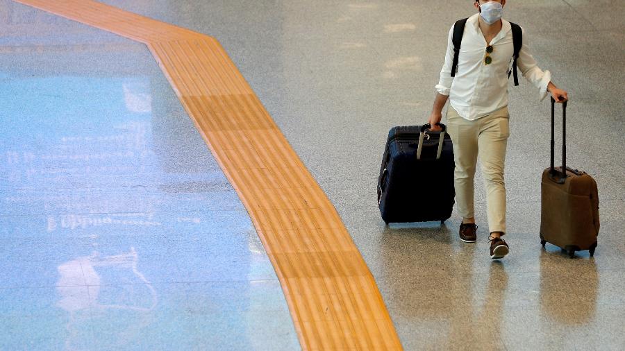 Passageira puxa suas malas no aeroporto Fiumicino, em Roma - Guglielmo Mangiapane