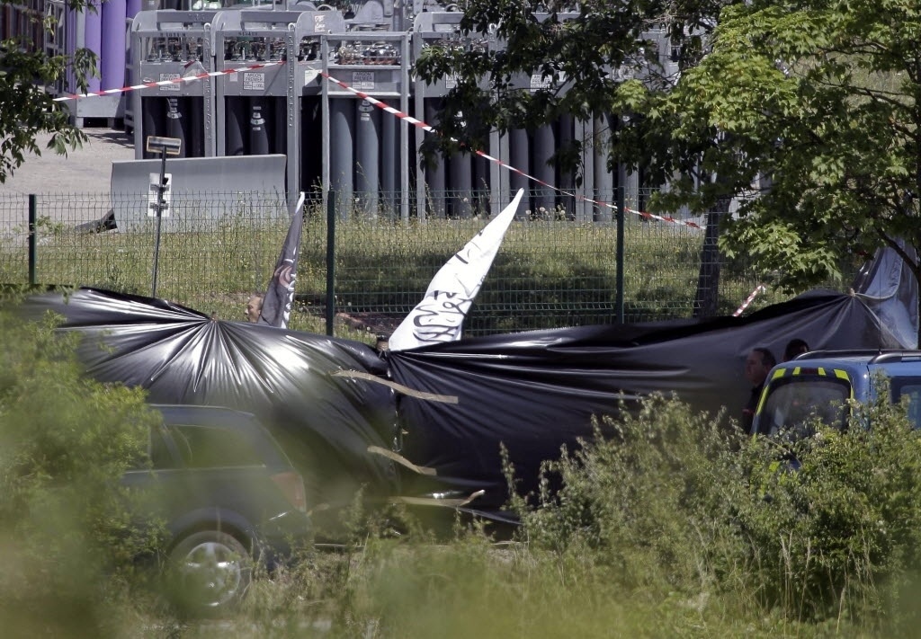 26.jun.2015 - Oficiais recolhem faixas com escrita árabe encontradas nos arredores de usina em Saint-Quentin-Fallavier, próximo a Lyon, na França. Segundo autoridades, houve uma explosão no local após a entrada de um ou mais indivíduos - EFE