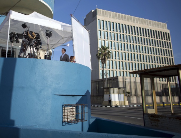 Repórter fala em frente ao Escritório de Interesses dos EUA (dir) em Havana, Cuba  - Alexandre Meneghini/Reuters