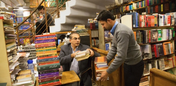 Ahmad Saeed (à esquerda) assume administração da Saeed Reserve Bank, uma das maiores livrarias do mundo, em Islamabad (Paquistão). Ele sempre esteve destinado a assumir os negócios da família - Danial Shah / The New York Times