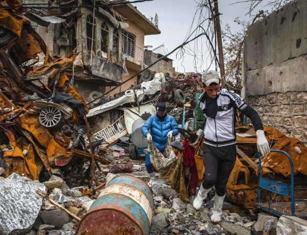 Lixeiros coletam corpo em distrito a oeste de Mosul, no Iraque - Ivor Prickett/The New York Times