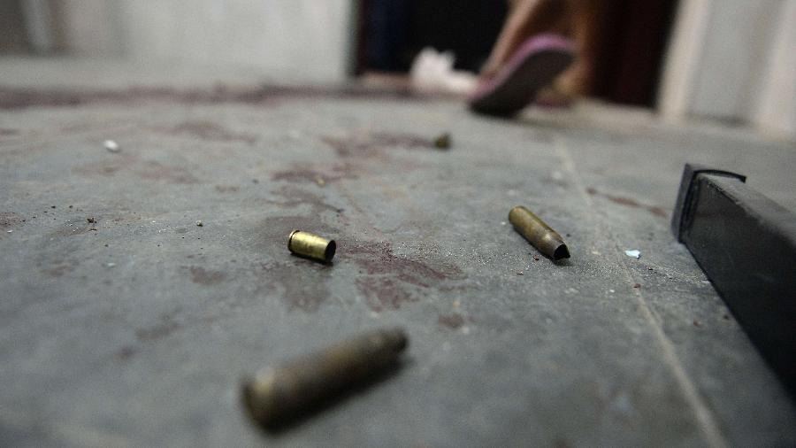25.jun.2013 - Capsulas de balas ficam no chão em frente a uma casa em um complexo de favelas do Rio de Janeiro - Yuri Cortez/AFP - 25.jun.2013