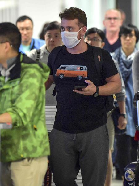 26.fev.2020 - Passageiro usa máscara ao desembarcar no Aeroporto Internacional de Guarulhos, em São Paulo. Brasil confirmou primeiro caso do novo coronavírus - NELSON ALMEIDA / AFP