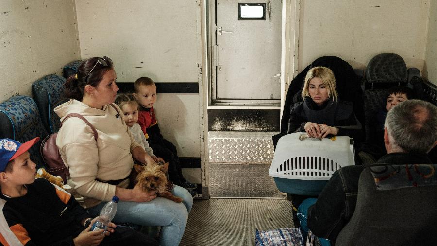 15.mai.22 - Famílias esperam em um veículo blindado antes de serem evacuadas, em Lysychansk, leste da Ucrânia - YASUYOSHI CHIBA/AFP