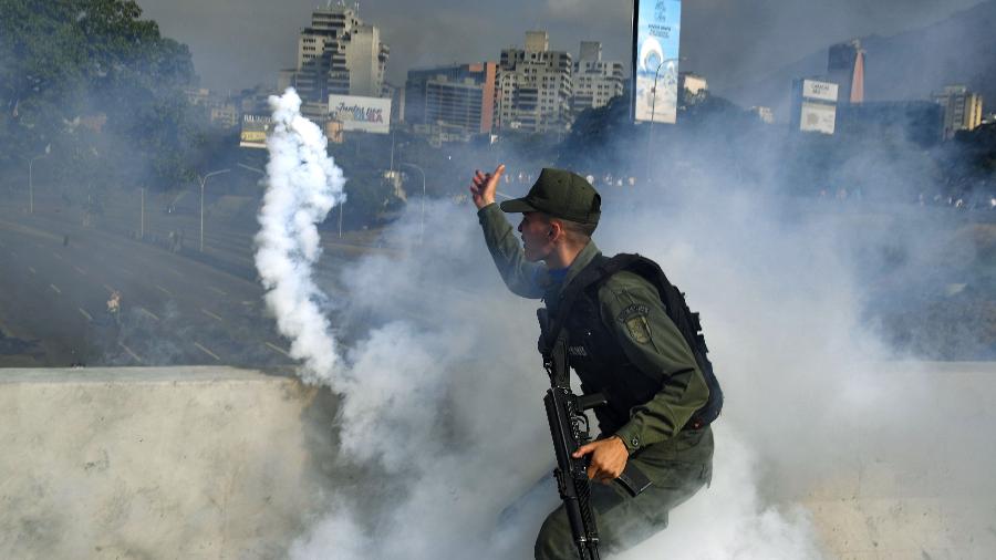 30.abr.2019 - Soldado que apoia Nicolás Maduro lança bomba de gás lacrimogêneo contra opositores em Caracas, capital da Venezuela, durante levante organziado pela oposição - Yuri Cortez/AFP
