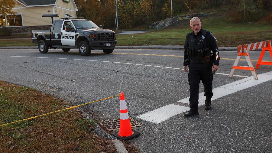 Um policial monta guarda perto da pista de boliche Just-In-Time Recreation, um dos locais dos tiroteios em massa mortais, em Lewiston, Maine, EUA, 27 de outubro de 2023