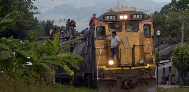 24.jun.2015 - Imigrantes se penduram em trem que chega a Salto del Agua, no Estado de Chiapas, México - Alfredo Estrella/AFP