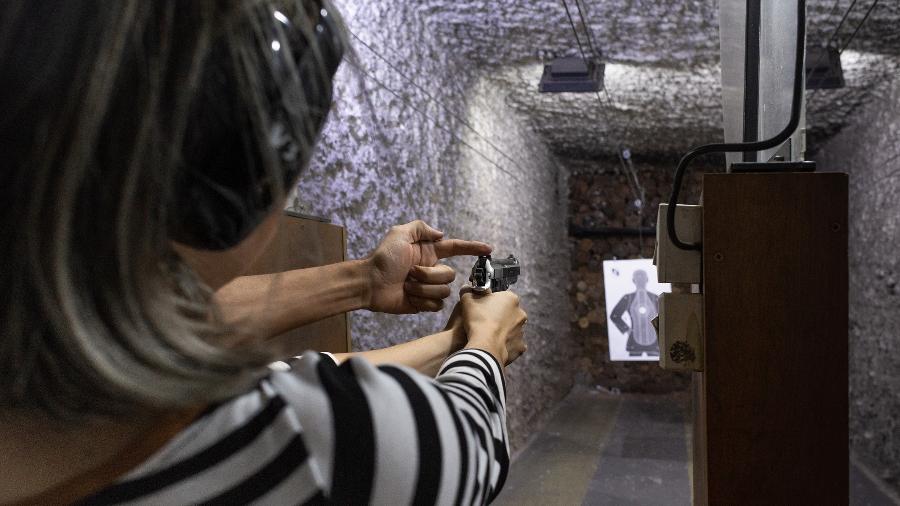 Instrutor ajuda Natalia Ortega durante sua prática de tiro em uma academia de treinamento de armas em São Paulo - Gabriela Portilho/The New York Times