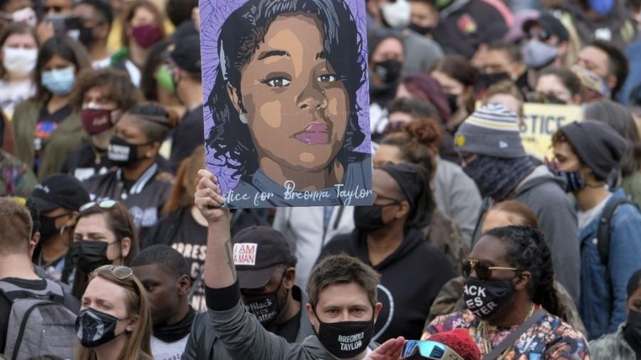 Manifestante segura o retrato de Breonna Taylor em ato em Louisville que lembra um ano da morte dela - 13.mar.2021 - Jeff Dean/AFP