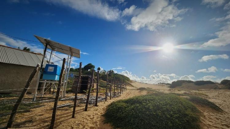 Casa com placas e gerador de energia solar sobre dunas da comunidade Pìxaim, em Piaçabuçu (AL)
