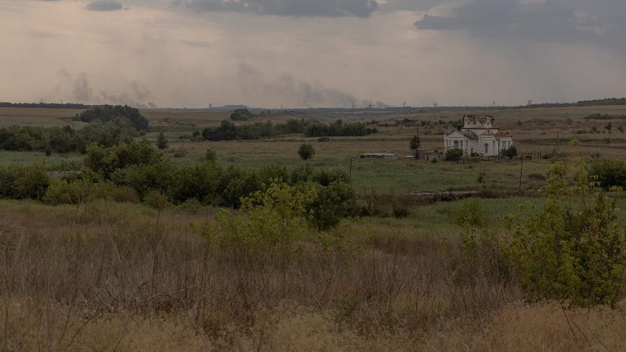 04.ago.24 - Fumaça subindo da direção de Toretsk e a Igreja de São Jorge destruída após o bombardeio, na vila de Oleksandro-Shultyne, na região oriental de Donetsk