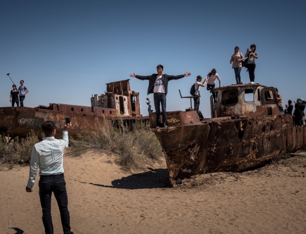 Turistas sobem em navios encalhados e enferrujados em Muynak, no Uzbequistão - Sergey Ponomarev/The New York Times