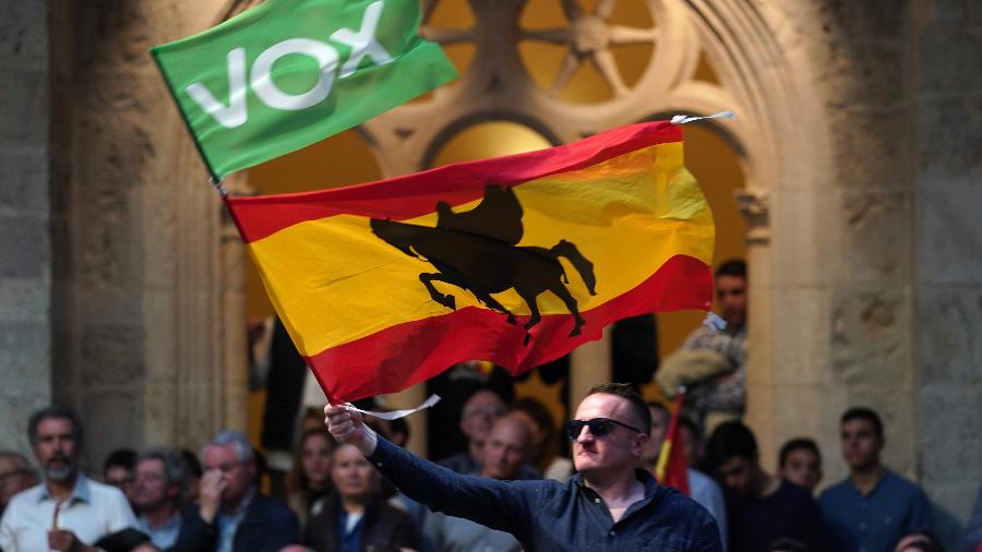 14.abr.2019 - Homem agita uma bandeira espanhola com a silhueta do nobre medieval espanhol e líder militar Rodrigo Díaz de Vivar "El Cid", durante um comício de campanha do partido de extrema-direita Vox, em Burgos, norte da Espanha