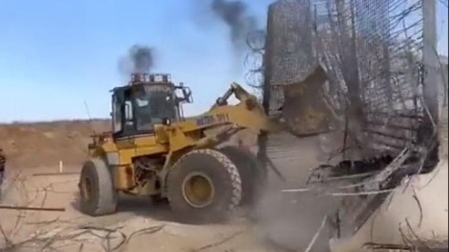 Retroescavadeira é utilizada para derrubar cerca com arame farpado na fronteira da Faixa de Gaza com Israel