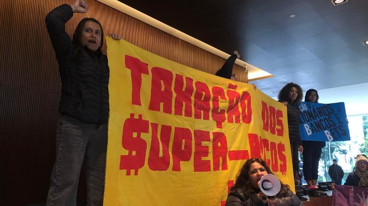 Manifestantes pedem a taxação de bilionários na sede do Itau, em São Paulo Manifestantes pedem a taxação de bilionários na sede do Itau, em São Paulo