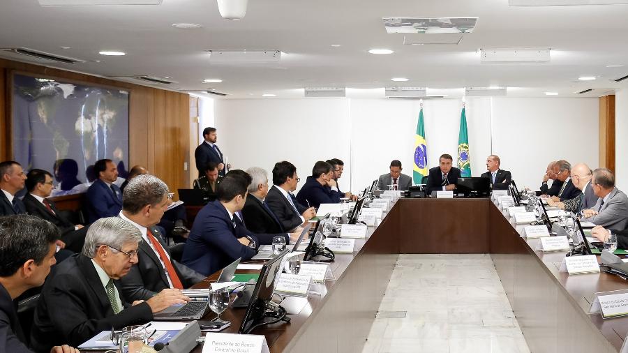 15.jan.2019 - Carlos Bolsonaro (à esquerda, de terno azul) acompanha reunião do presidente Jair Bolsonaro com seus ministros no Planalto - Alan Santos/PR