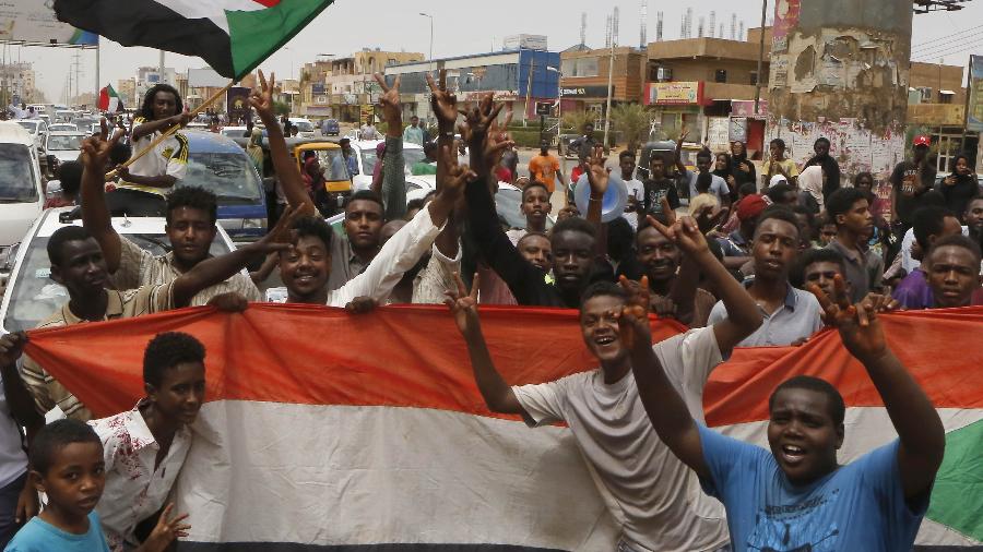 Sudaneses celebram nas ruas de Cartum depois que militares e oposição anunciaram um acordo sobre governo transitório - Ashraf Shazly/AFP