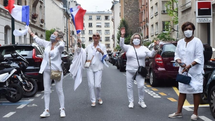 10.mai.2020 - Em Saint-Mande, francesas saem às ruas de branco e com bandeiras para homenagear os profissionais de saúde - Stephane Cardinale/Corbis via Getty Images