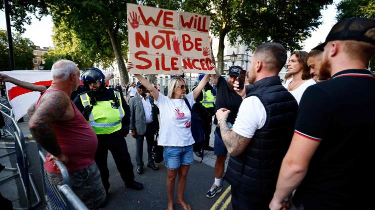 Manifestante segura cartaz no qual se lê "Não seremos silenciados" em ato em Londres após o assassinatos de cranças em Southport no dia 29 de julho