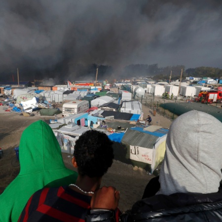 26.out.2016 - Imigrantes observam incêndio de barracas no acampamento de Calais, na França - Philippe Wojazer/ Reuters