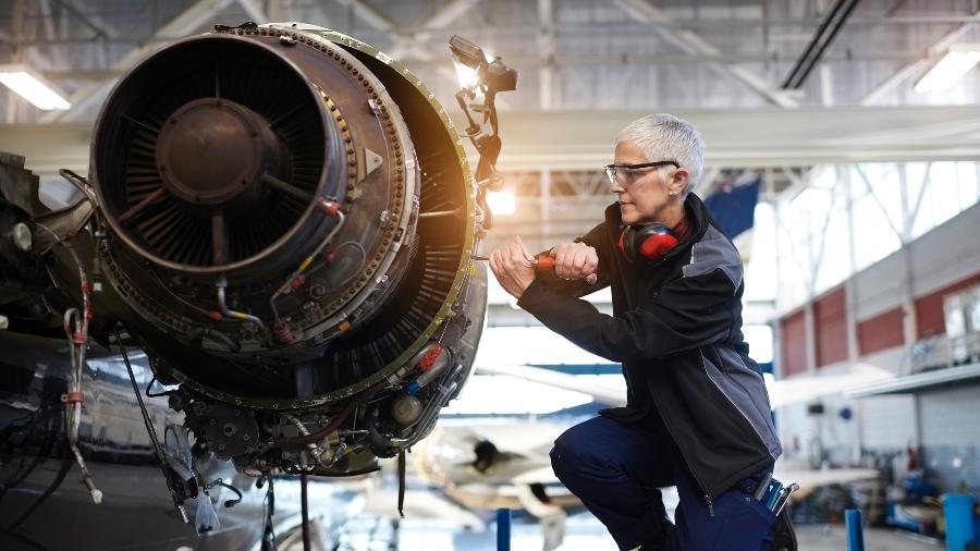 Engenheira faz reparos em uma turbina de avião - Getty Images