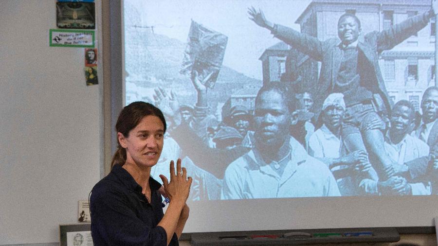 Leah Nasson, professora de história, mostra uma foto do ativista anti-apartheid Philip Kgosana durante aula sobre o tema na escola para meninas Herschel, na Cidade do Cabo - Rodger Bosch/AFP
