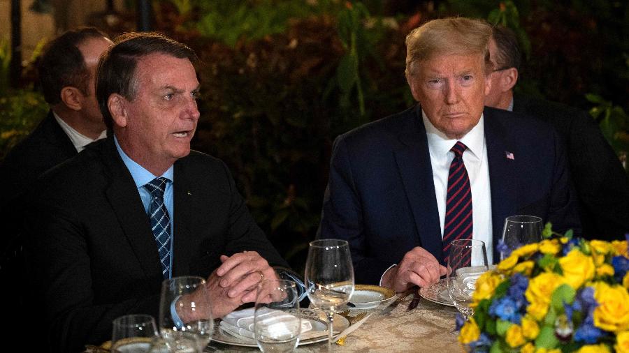 O presidente do Brasil, Jair Bolsonaro, e o presidente dos EUA, Donald Trump, durante jantar na Flórida - Jim Watson/AFP