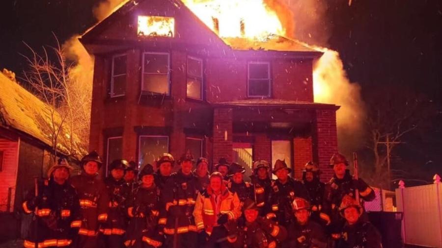 Bombeiros de Detroit, nos EUA, posaram em frente a uma casa em chamas às vésperas do Ano Novo; foto foi divulgada em redes sociais - Reprodução/WXYZ TV