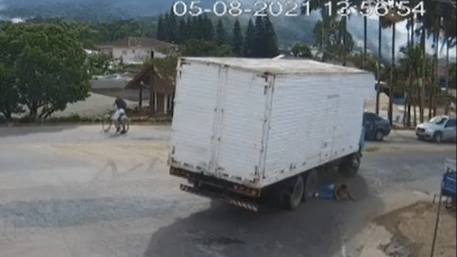 Imagens da câmera de monitoramento mostram a mulher saindo debaixo do veículo; ela se arrastou para não ser atingida pelas rodas do caminhão - Reprodução