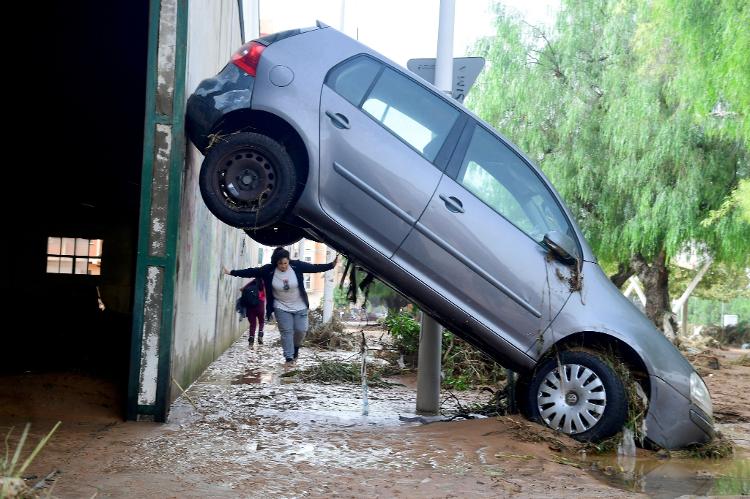 Carro fica tombado após enchente em Valência