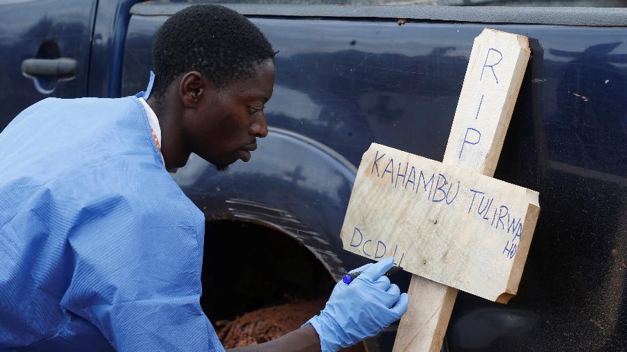 28.mar.2019 - Membro da Cruz Vermelha  escreve o nome da congolesa Kahambu Tulirwaho que morreu de Ebola - Baz Ratner/Reuters