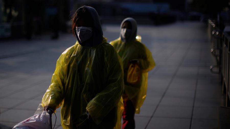 12.fev.2020 - Mulheres usam máscaras e capas de chuva em Shangai, para reforçar a proteção contra o coronavírus - ALY SONG/REUTERS