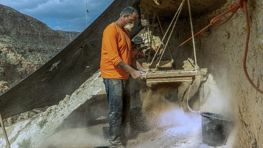 Arqueólogos e voluntários trabalham na caverna de Murabaat, no deserto da Judeia, em Israel; segundo Autoridade de Antiguidades de Israel, grupo encontrou itens raros, como moedas, esqueletos e cestos e cerca de 10 mil anos -  Yaniv Berman/Israeli Antiquities Authority/AFP