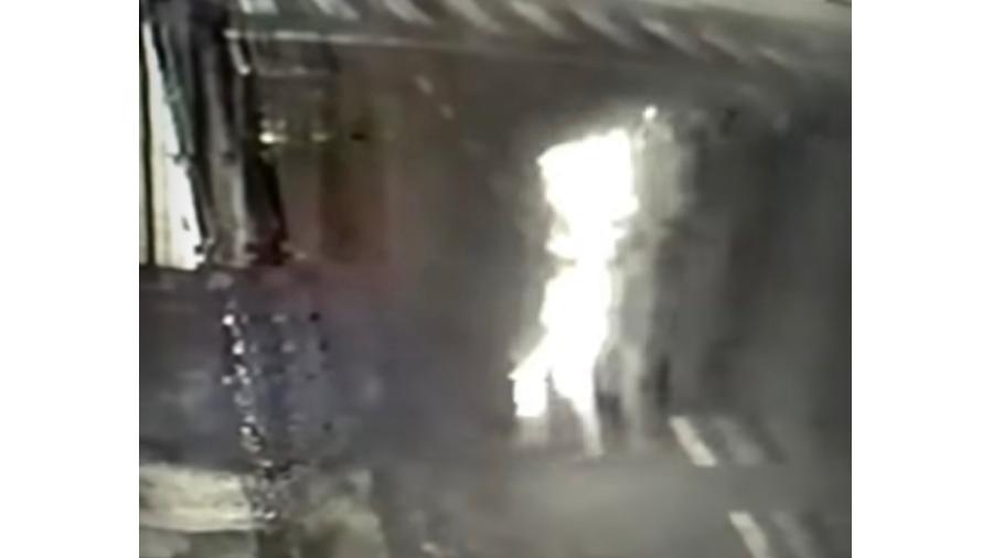 Câmera de segurança flagrou momento em que a mulher passa correndo desesperada com corpo coberto pelas chamas - Reprodução/ Redes sociais