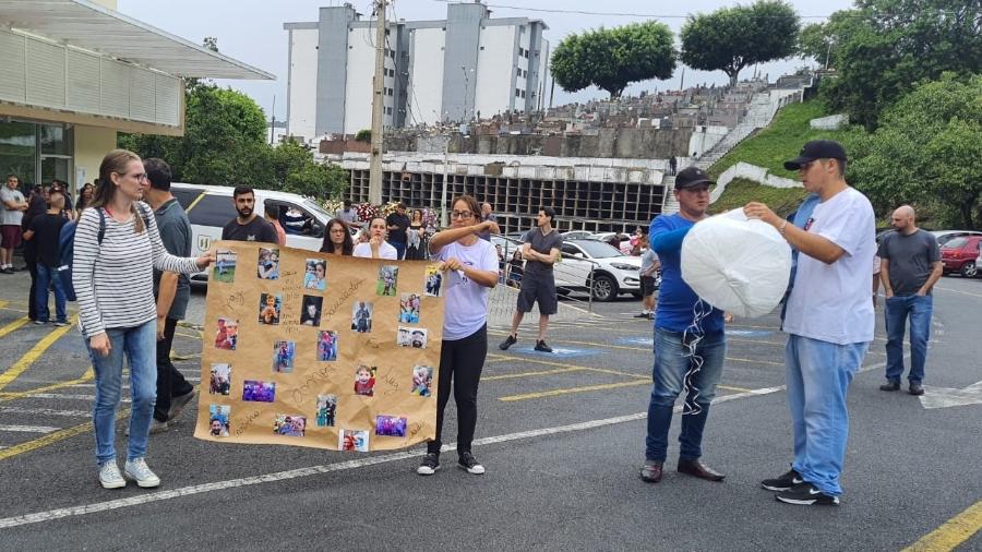 Parentes carregam um cartaz com fotos de uma das vítimas do ataque - Hygino Vasconcellos/UOL